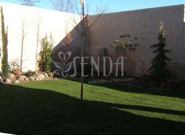 Paisajismo residencial con césped y arbolado ornamental