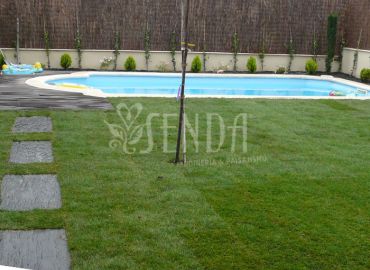 Jardín con piscina, pradera de césped y recorrido ornamental de piedra natural