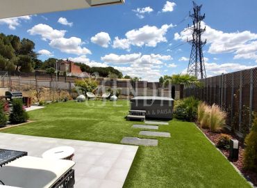 Diseño de jardín con terraza, camino de losas y plantación perimetral