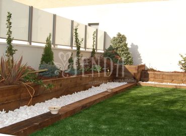 Jardín moderno con jardineras de madera y composición vegetal estructurada