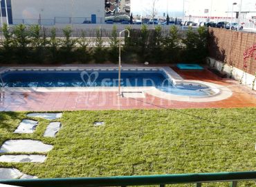 Jardín con piscina, césped y privacidad vegetal