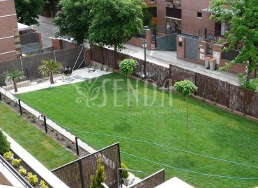 Jardín en dos niveles con gran pradera central y zona de piscina