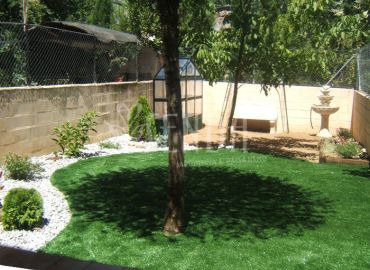 Jardín con pradera central, arbolado y rincón ornamental