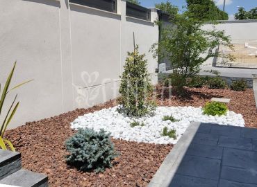 Diseño paisajístico con grava decorativa, vegetación ornamental y recorrido integrado